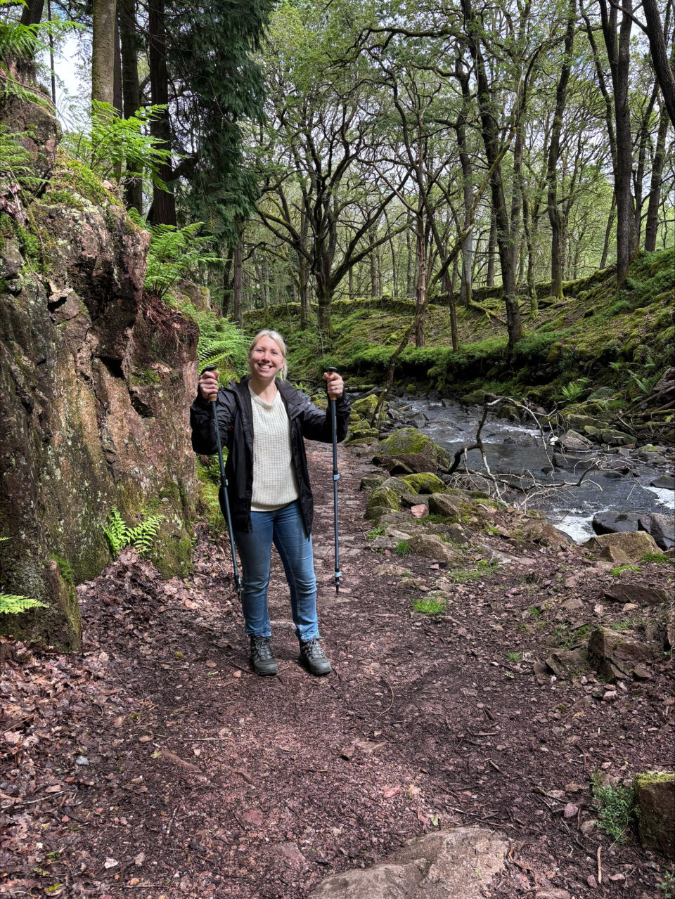 me holding up my walking poles at the start of the trail