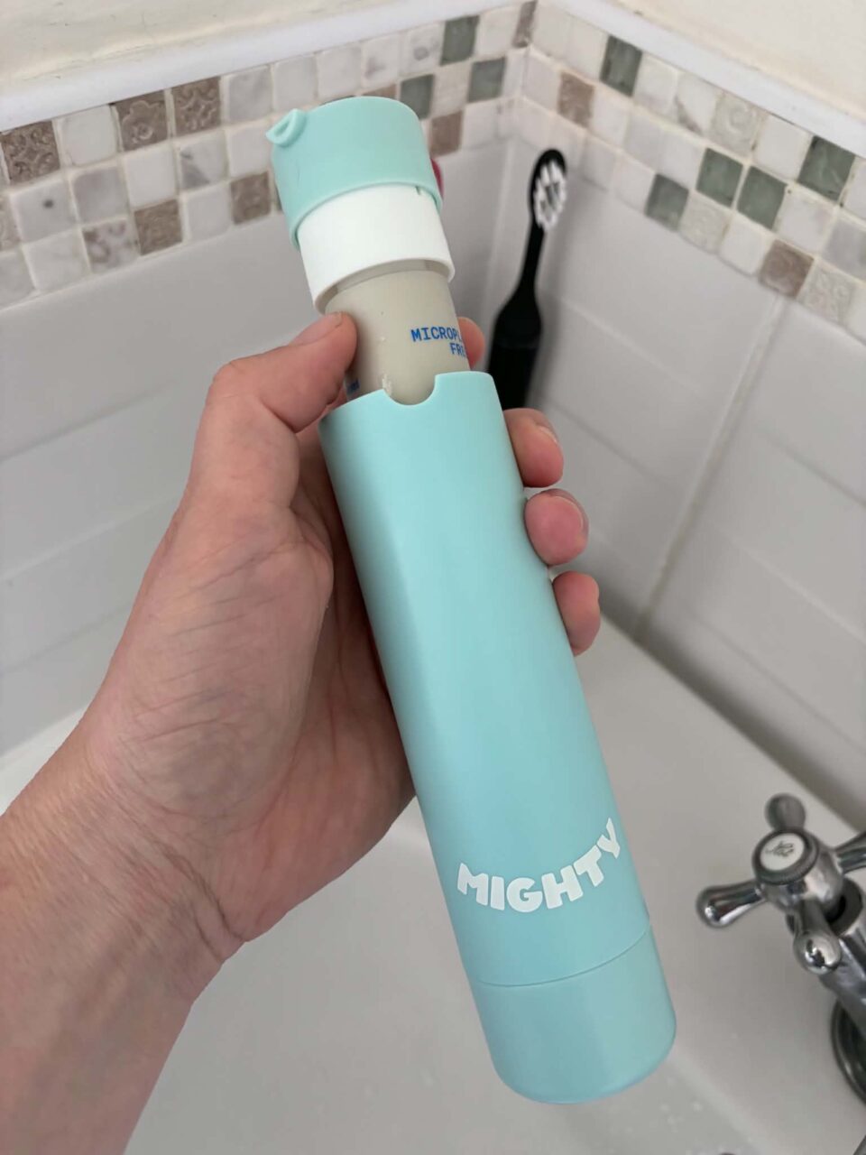 old version of mighy mouthcare dispenser being shown with lid going on