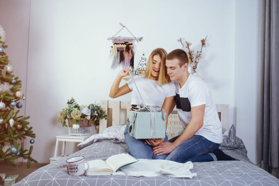 a woman unwrapping a gift with a male partner
