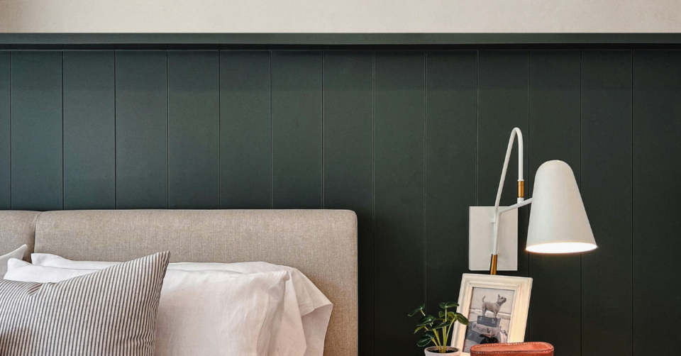 tongue and groove panelling painted dark green in a bedroom