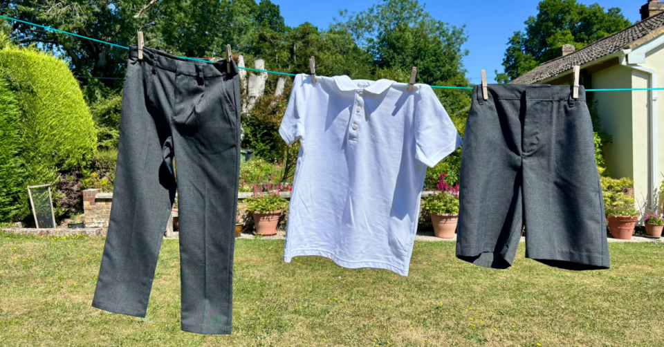 kids school uniform hanging on a line in the sunshine - white polo top, trousers and shorts
