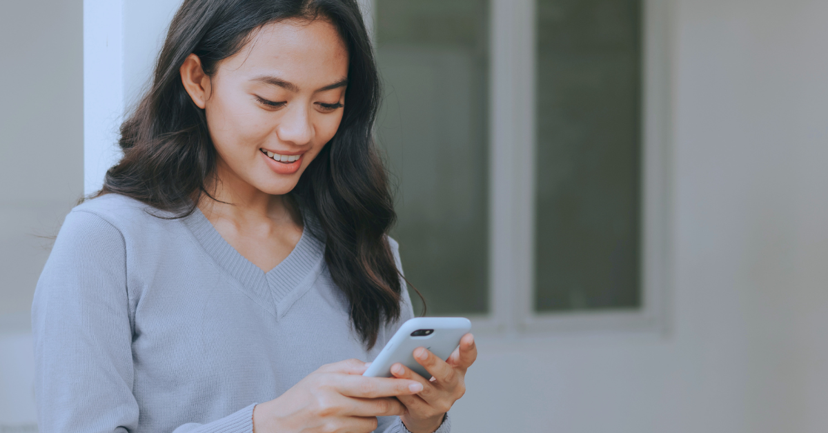 a lady smiling looking down at her phone