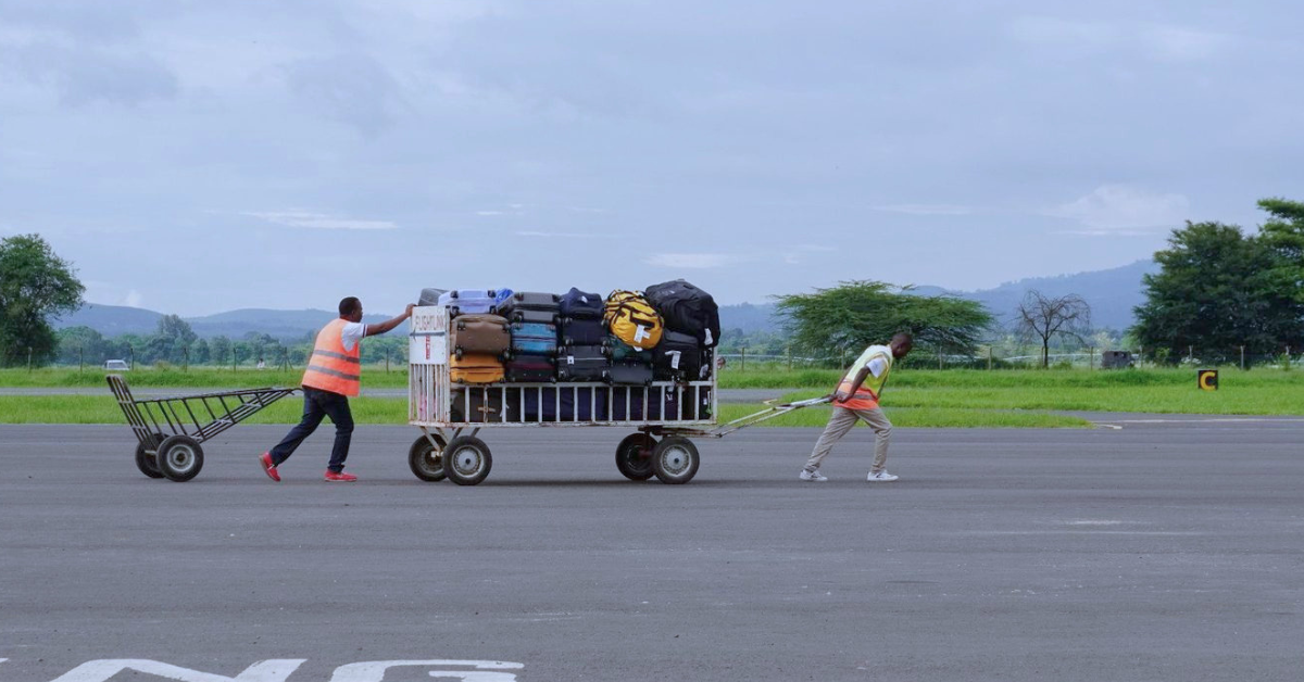 bulky gear being pushed by two people at an airport