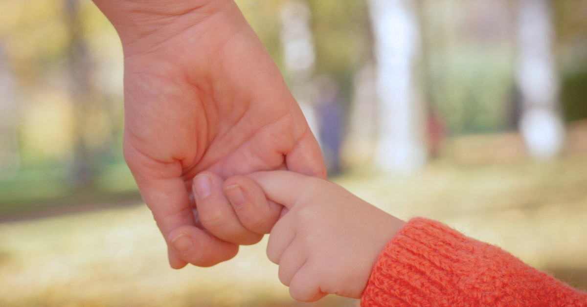 childs finger in parents hand