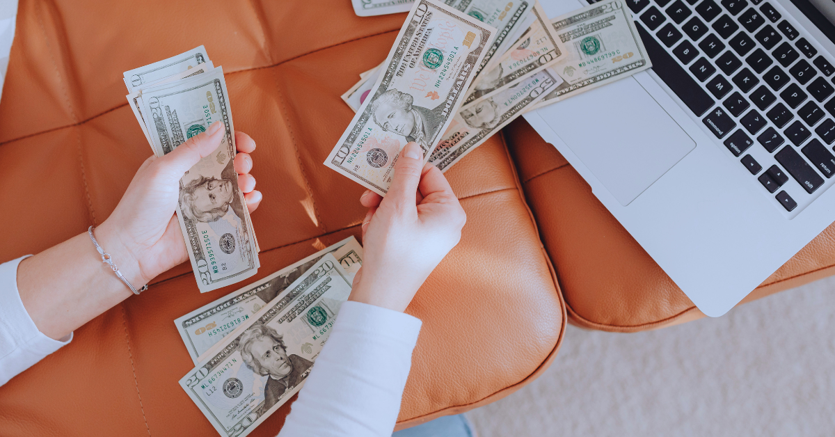 money being counted by a laptop