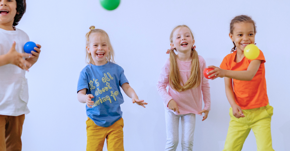 4 kids playing with balls and laughing