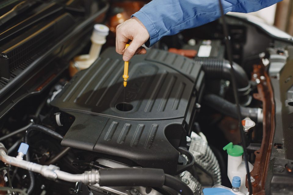 Man checking the engine oil before signing the papers