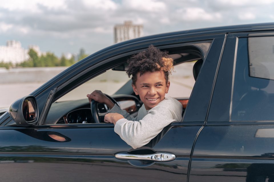 Teenager smiling after having gotten comfortable in their new car
